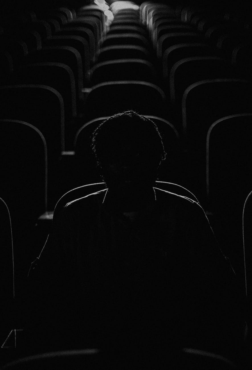 silhouette of man sitting in dark cinema